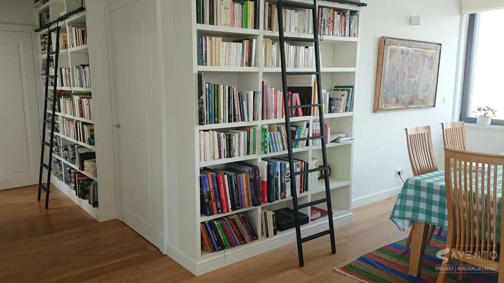 Biblioteka wykonana z płyty mdf lakierowanej na biały półmat, grube boki i czarna metalowa drabina nadają niepowtarzalnego wyglądu. Projekt MaKeNew, wykonanie Savento