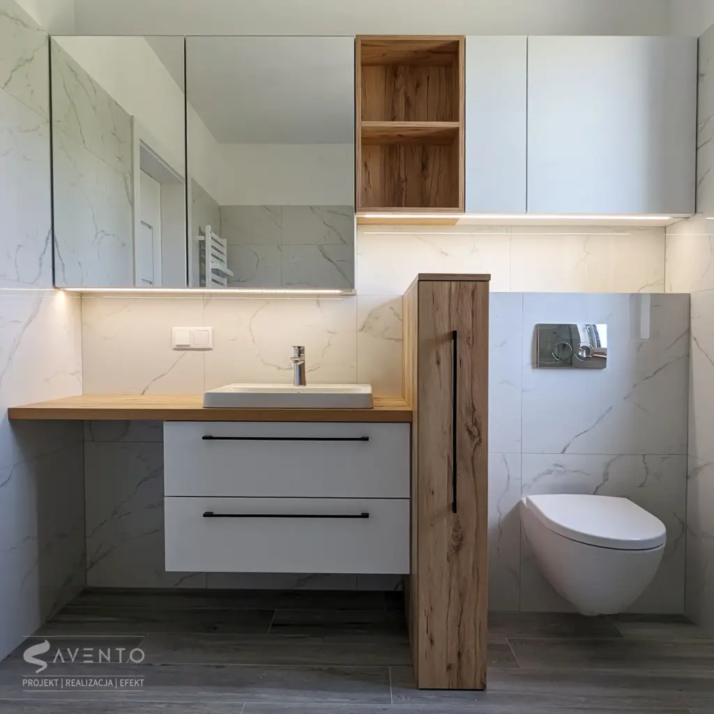 Zabudowa łazienki z szafką w lustrze nad umywalką. Szafka z szufladami jako oddzielenie umywalki i geberitu. Projekt Savento